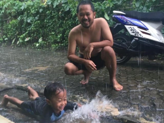 ayah dan anak mandi hujan